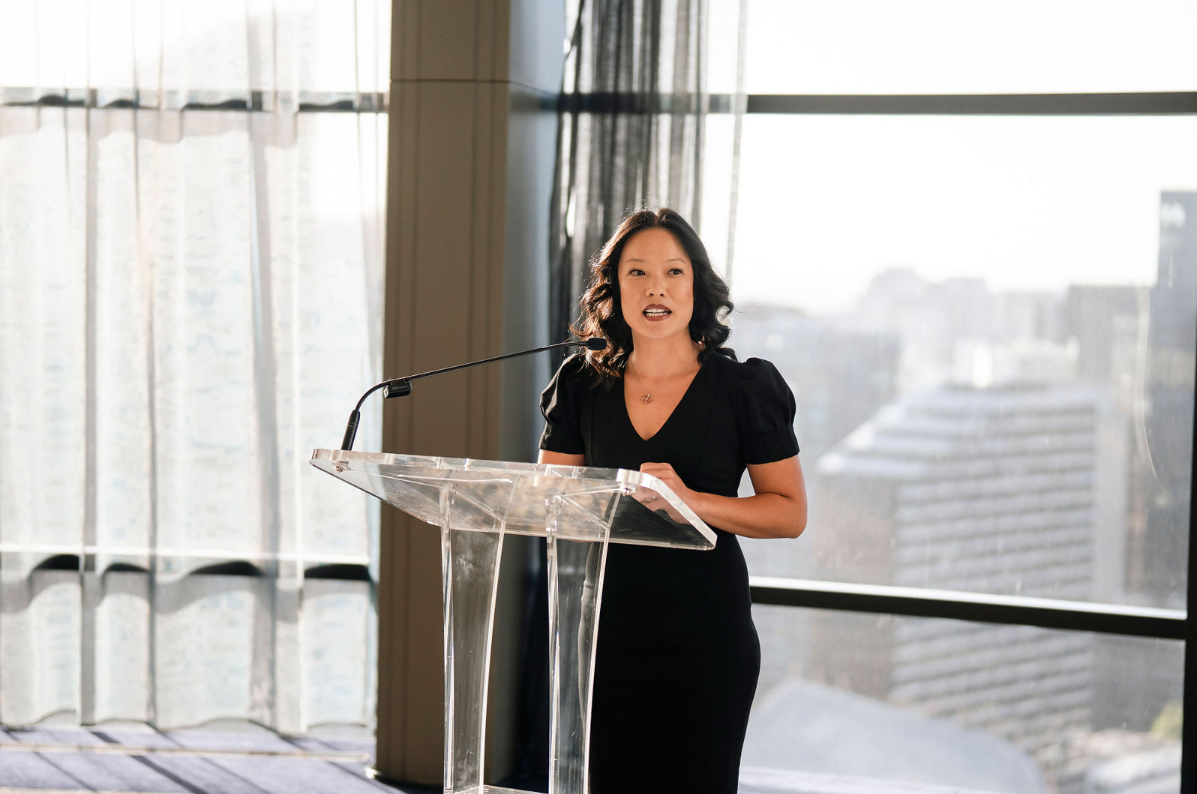 a woman giving a speech at a lectern