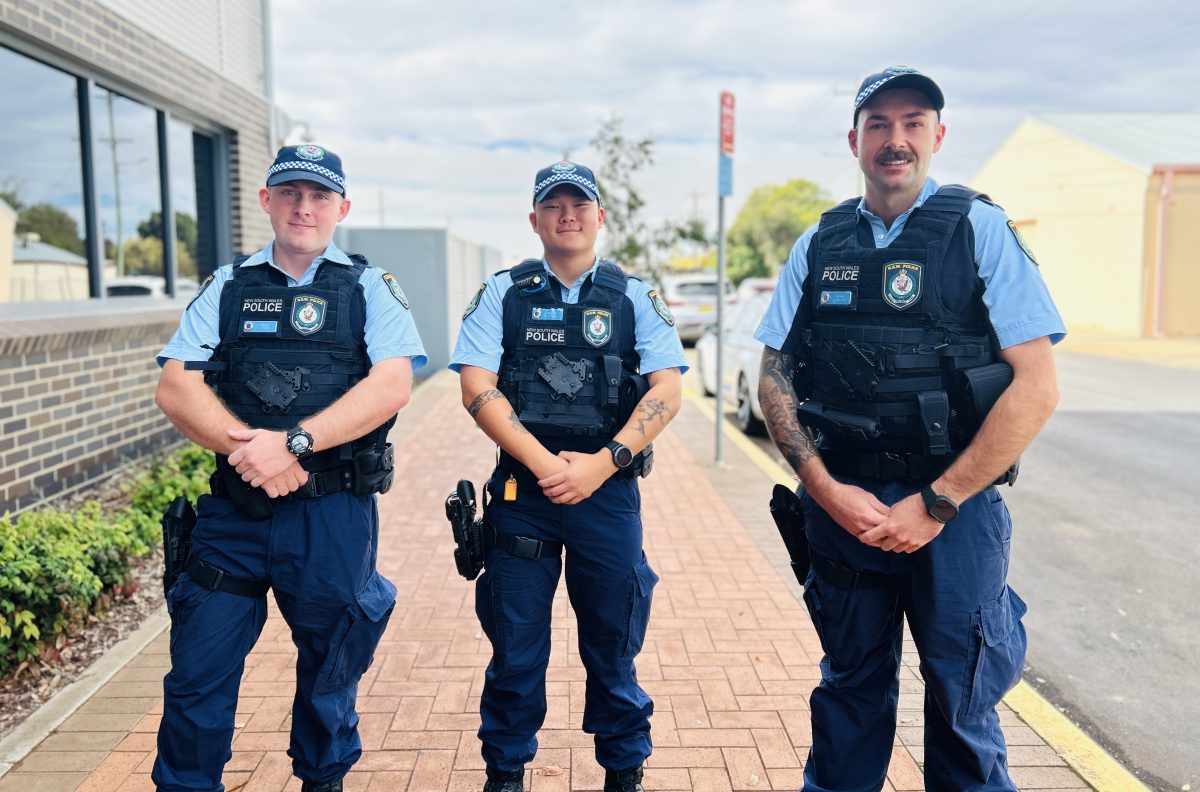 Three male cops in a row on a footpath