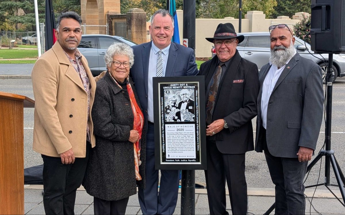 five people holding a plaque