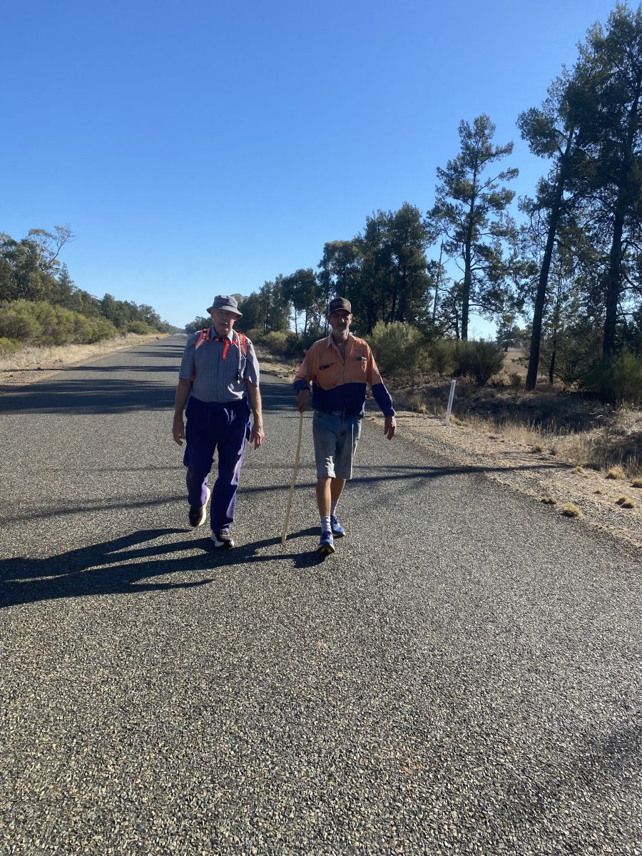 Two men walking on a road
