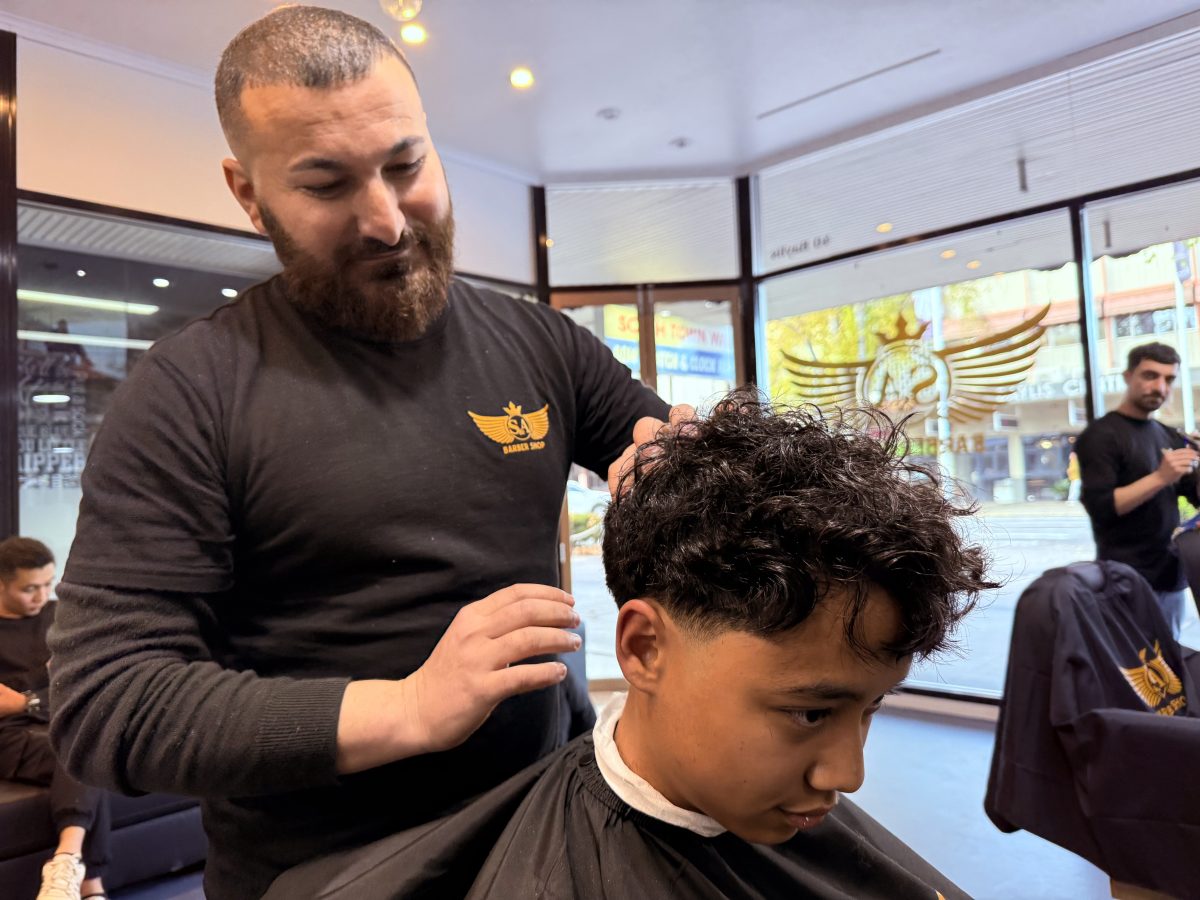 S&A Barber Sam Heseyan giving Mohammed, 14, another happy customer a haircut. Picture: Marguerite McKinnon