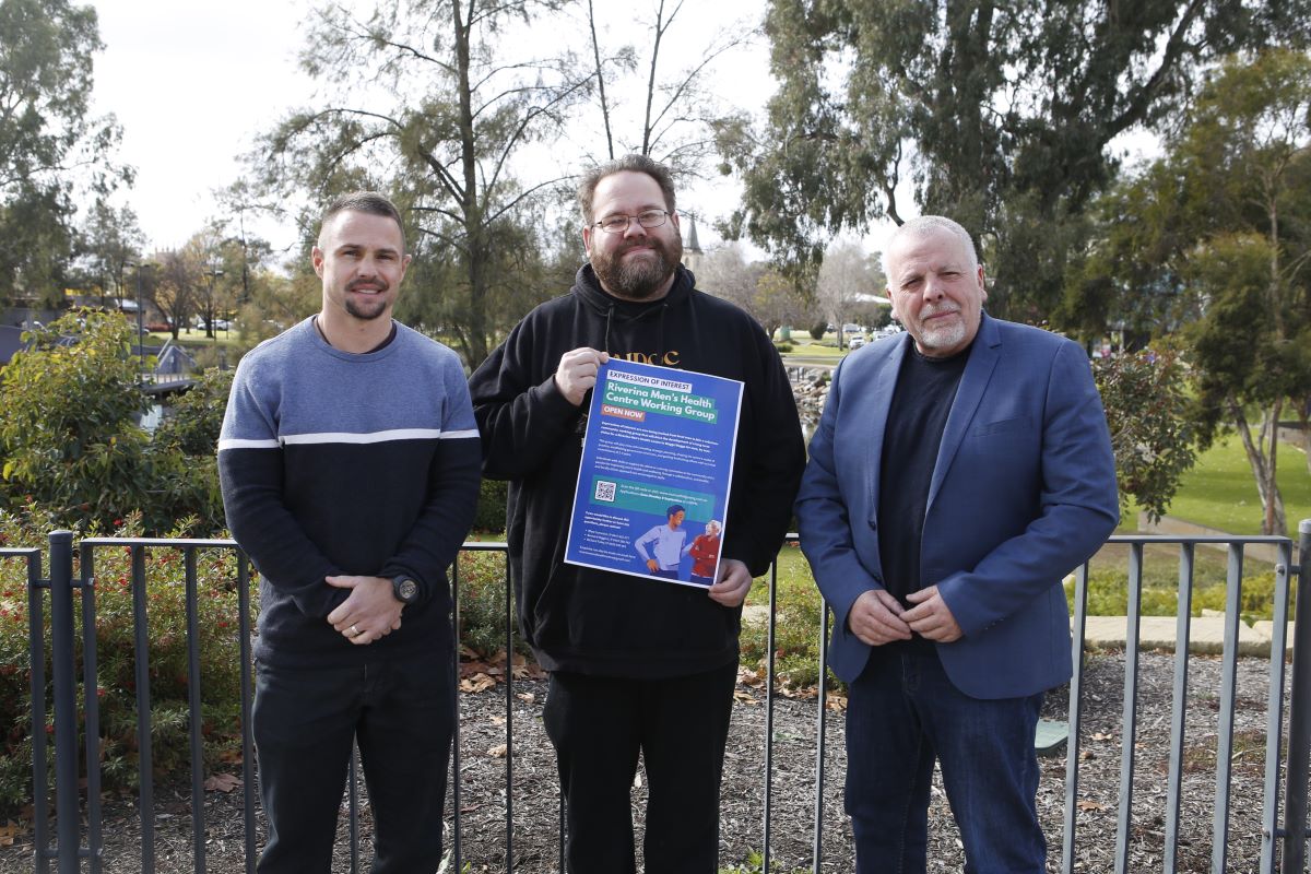 three men wih a poster