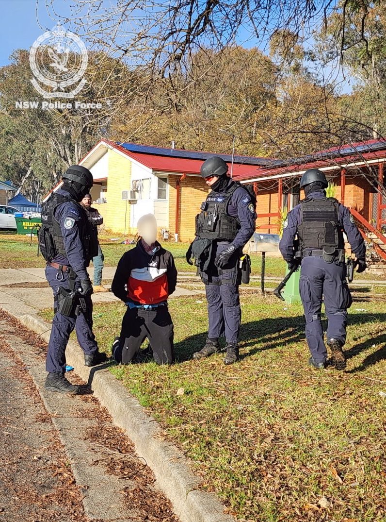 three police with suspect