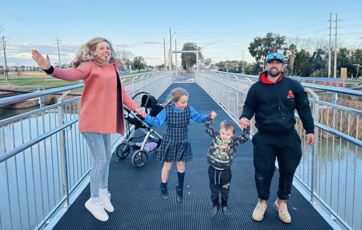 Family jumping on bridge