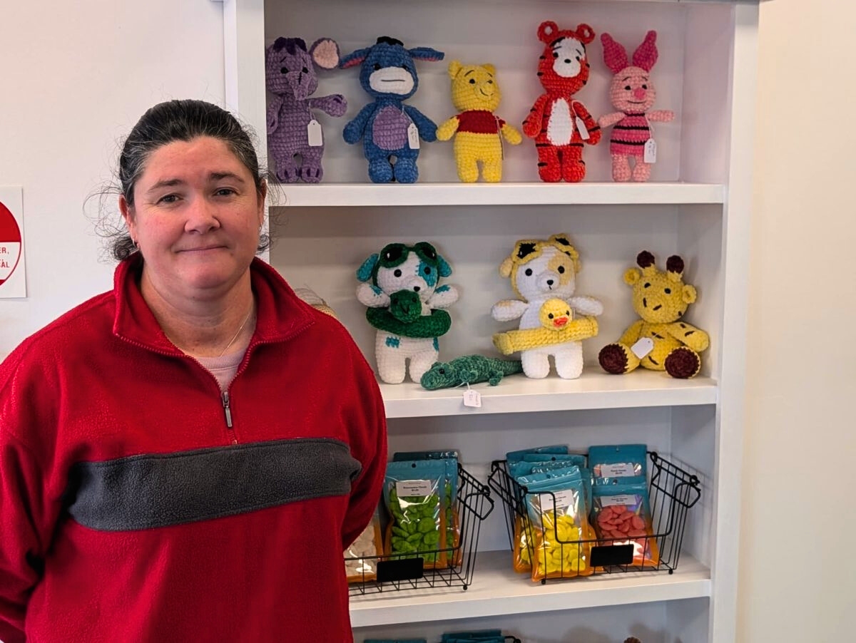 woman standing in front of knitted toys