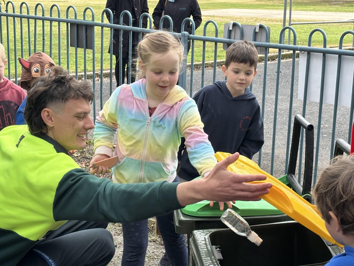 Waste education officer Sam Holt shows children how to properly categorise their trash. 