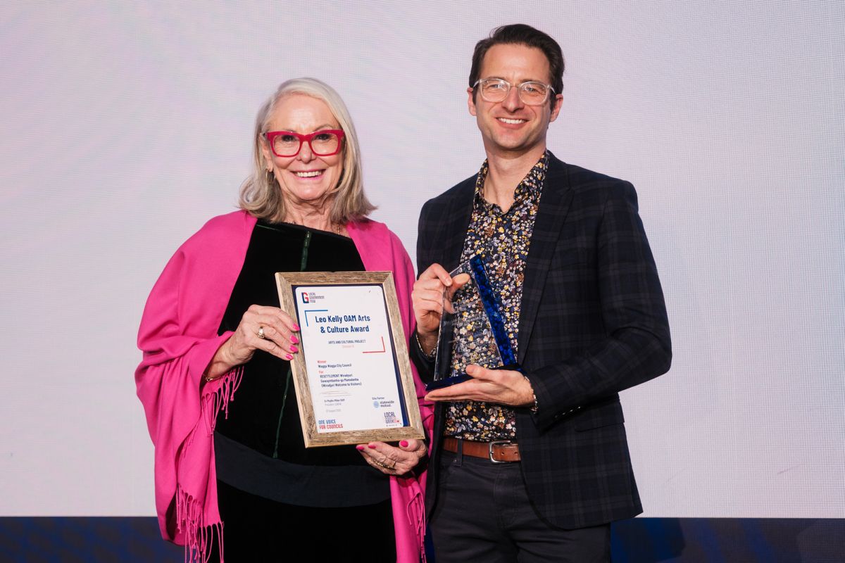 a woman and a man with an award
