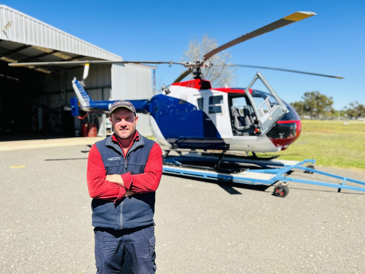 Pilot in front of helicopter