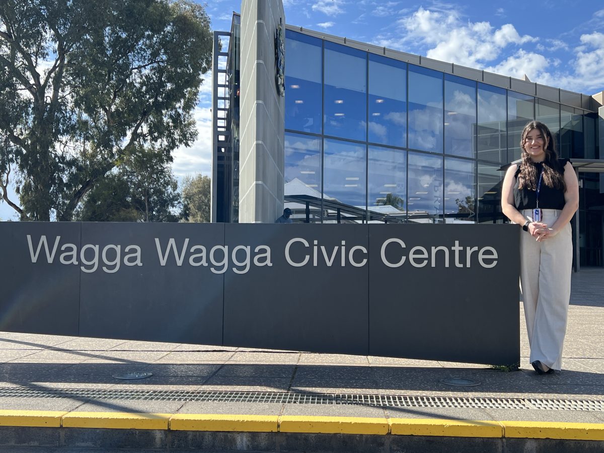 A young woman standing next to a building and sign