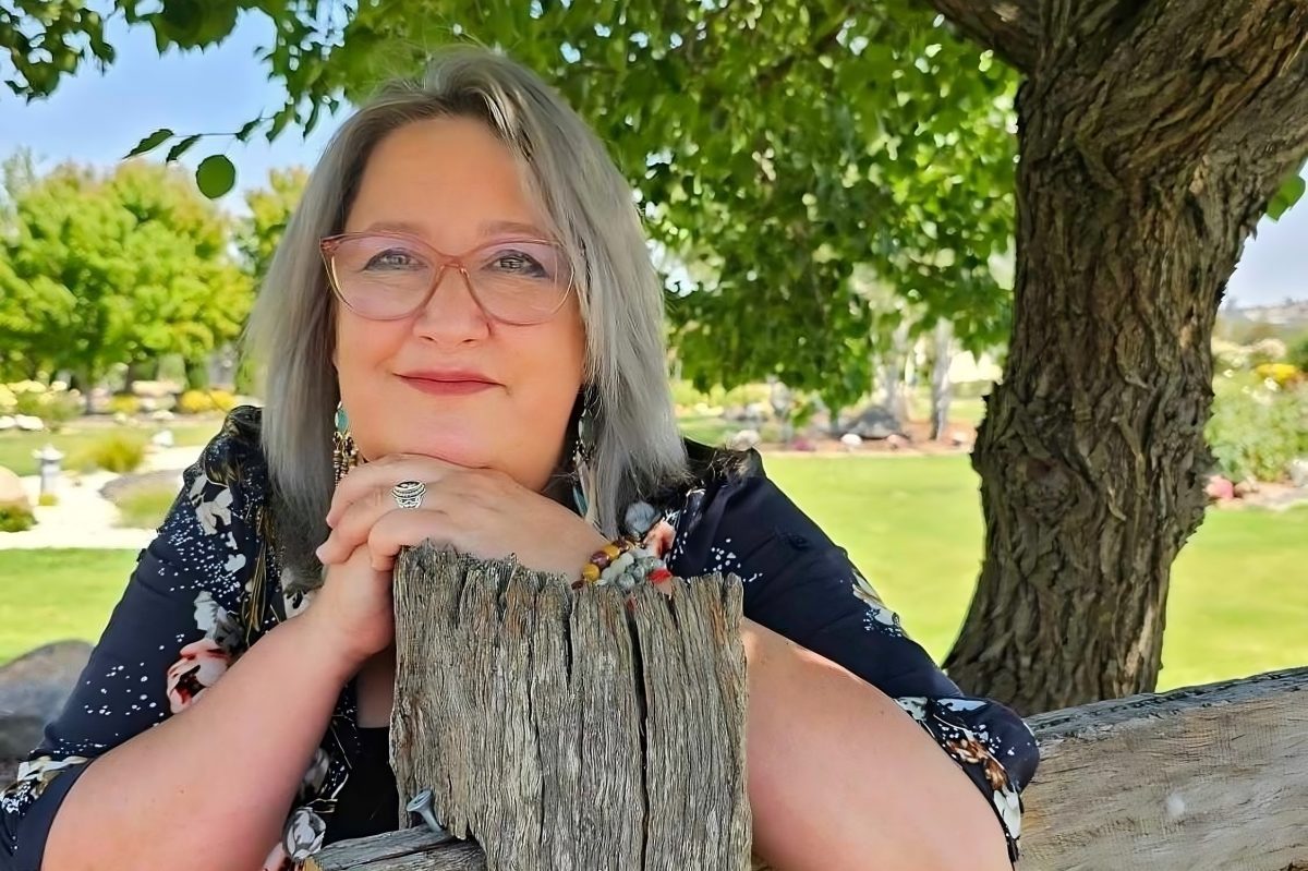Woman sitting on a bench near a tree