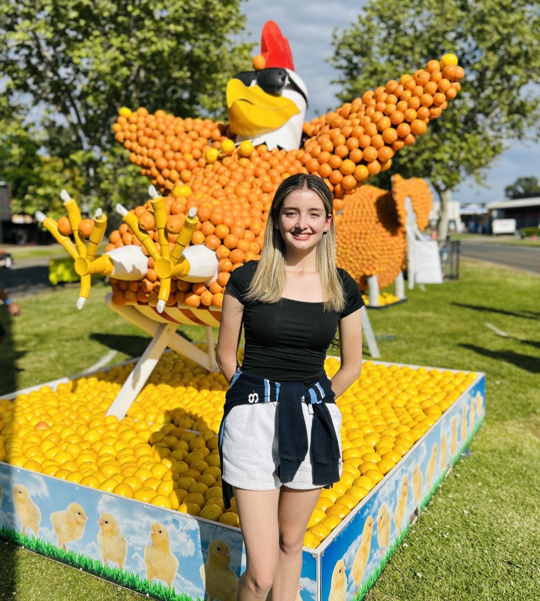 girl in front of chicken citrus sculpture