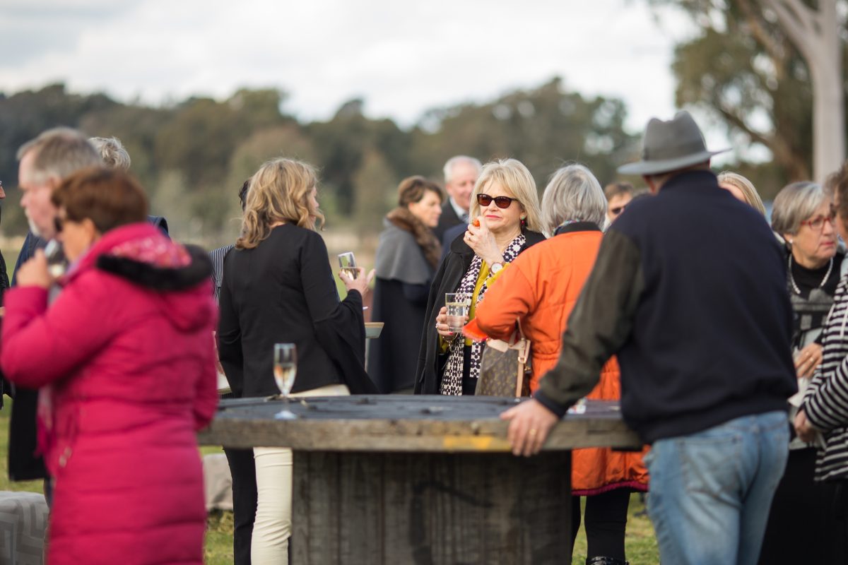 people drinking wine while gathered at an outdoor social event