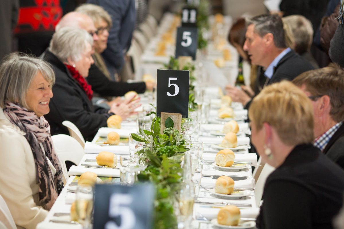 people sitting at a long dinner table