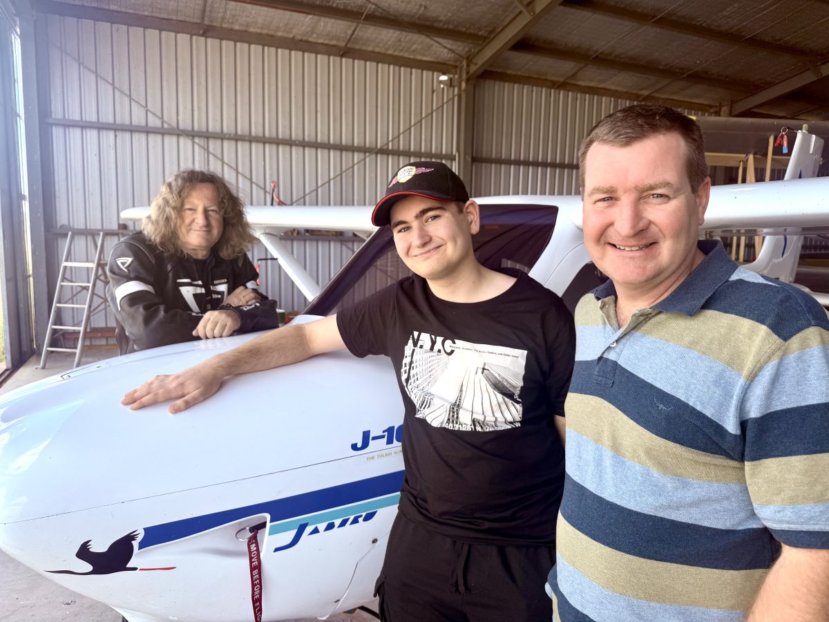 a boy and two men with a small plane