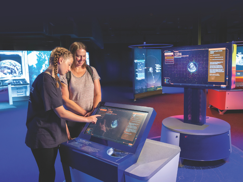 two young women at an exhibition about space