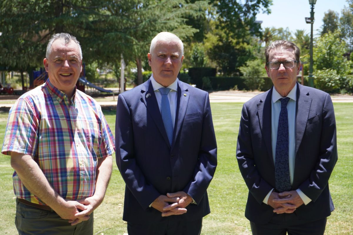 three men standing in a park