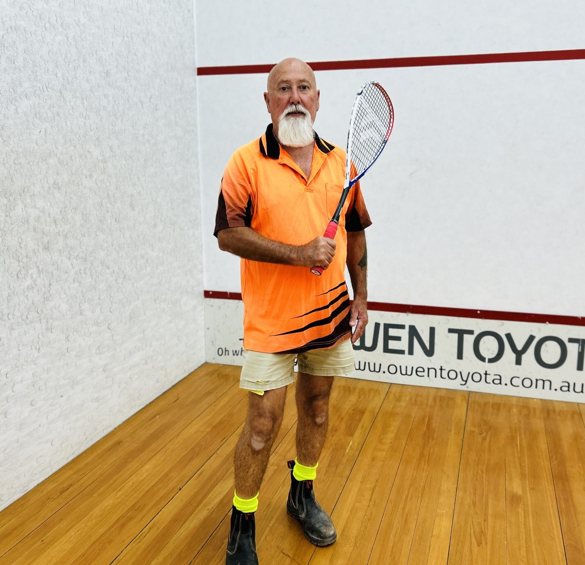Guy with squash racquet in court 