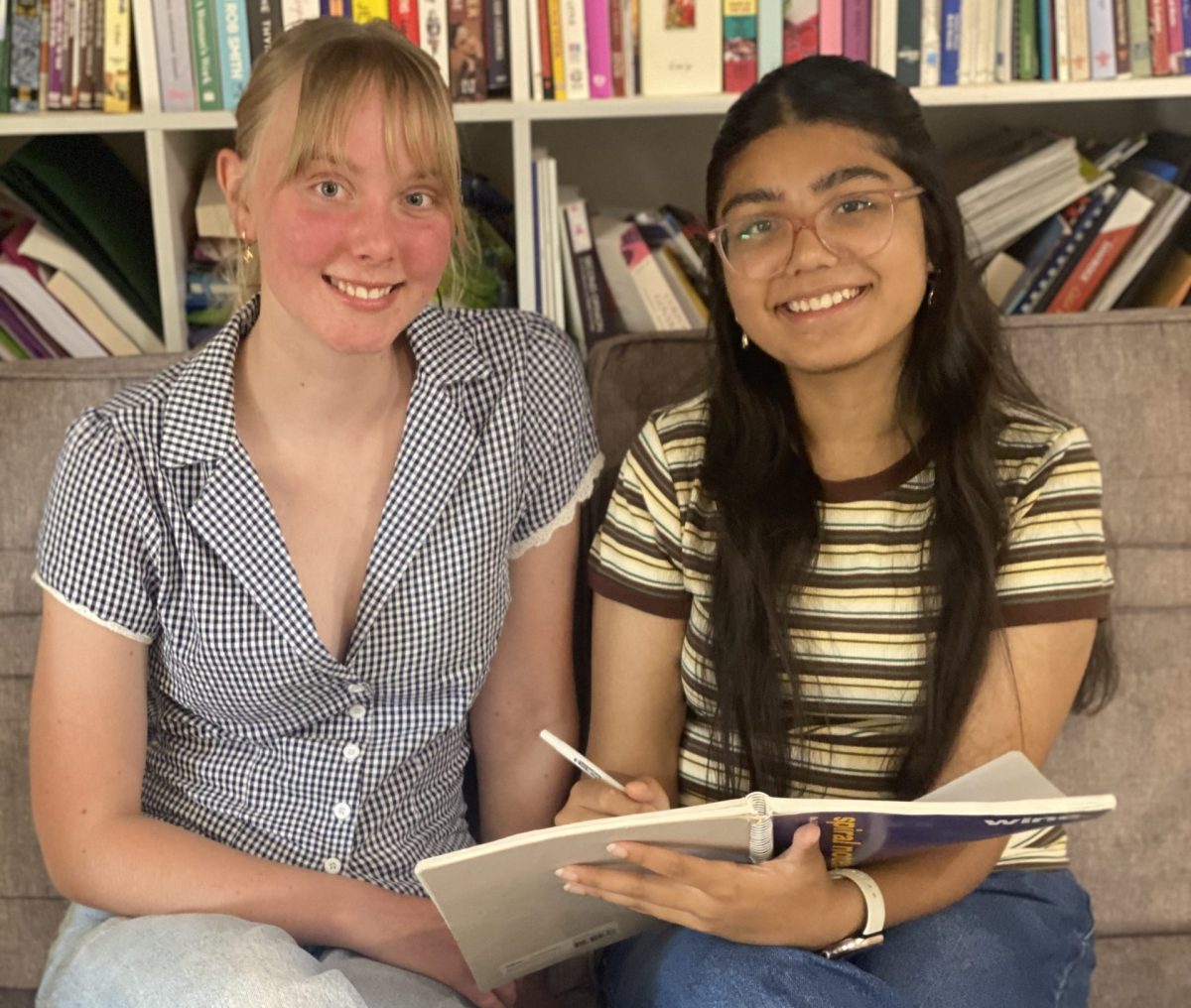 two girls together with book 