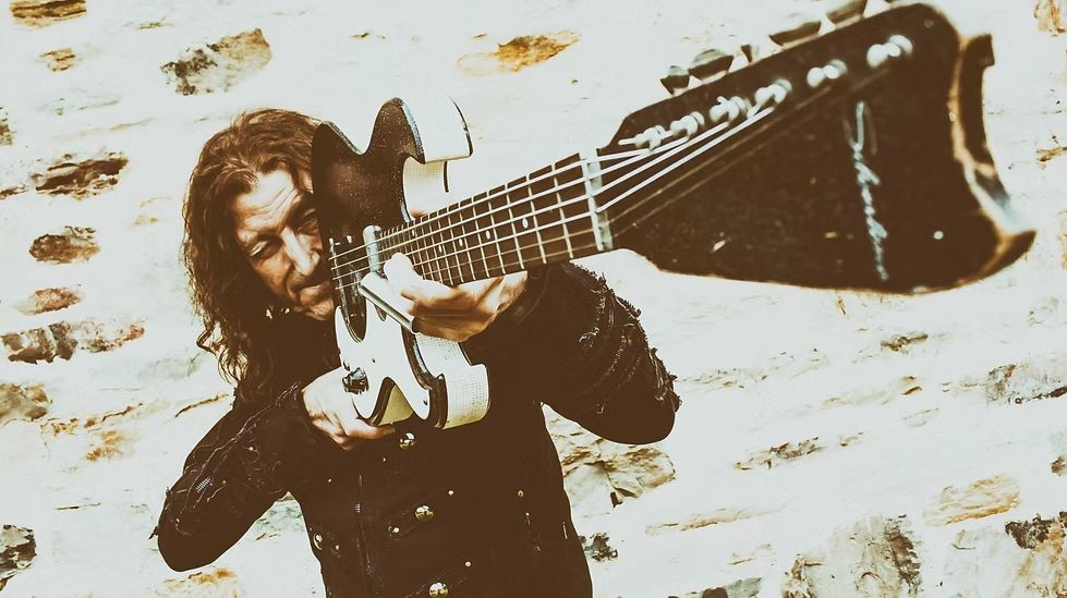 man looking down his guitar