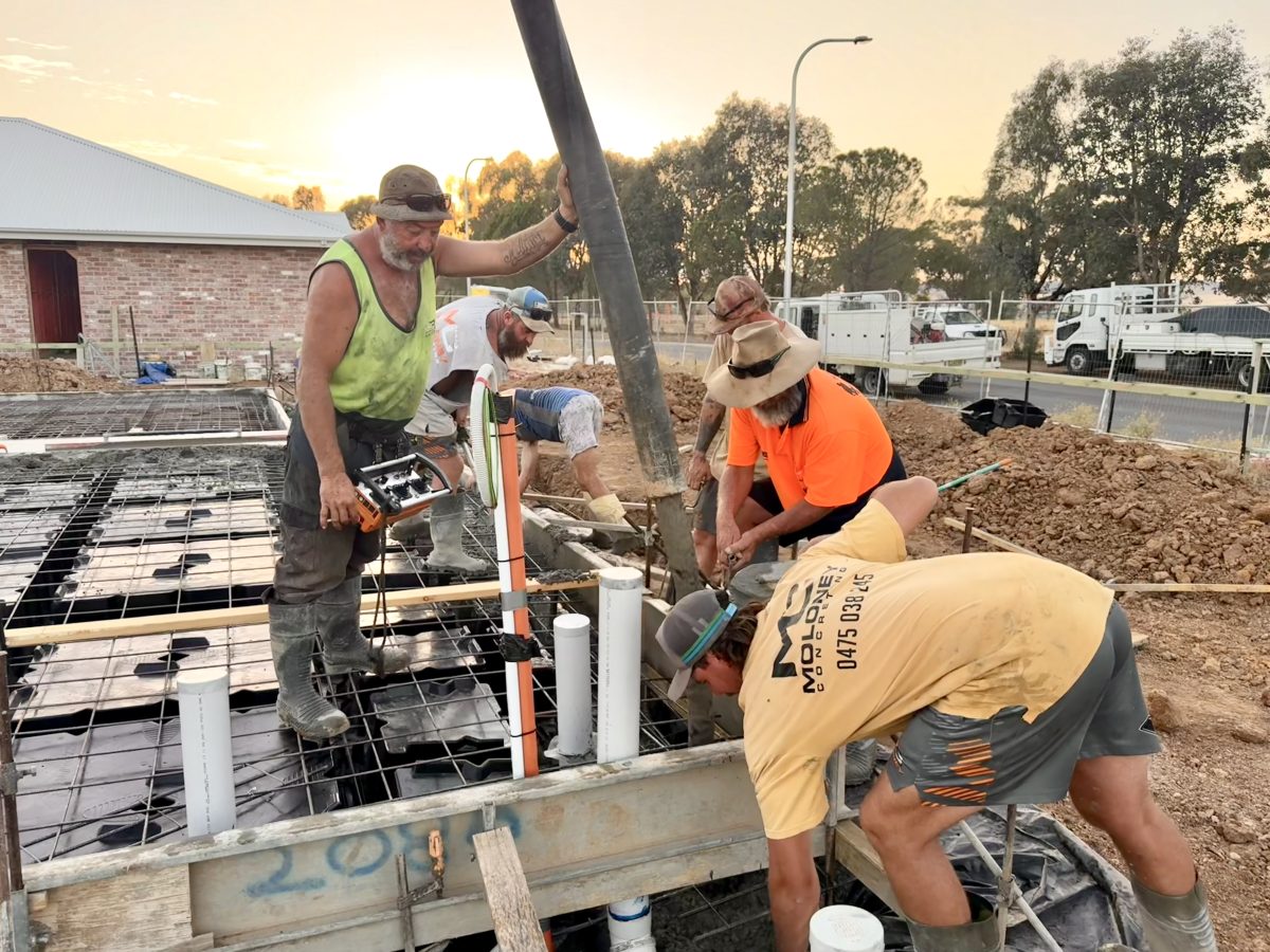 Concrete laying before sunrise at one of the new houses in Forest Hill as workers get in early to beat the heat. 