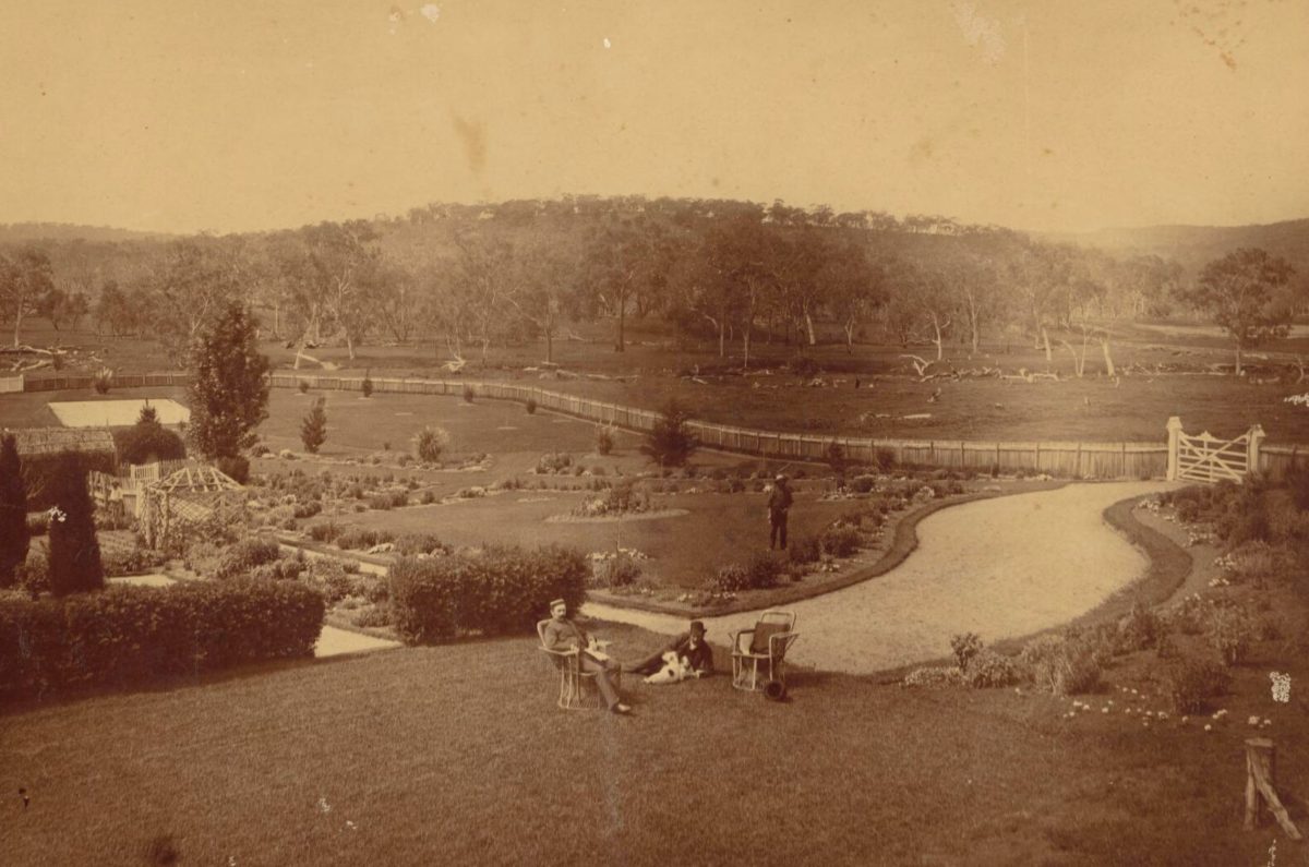 A pair of gentlemen take their leisure in Pulletop Gardens' well-watered lawns while the gardener watches on.