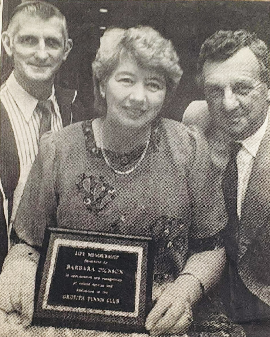 black and white photo of lady holding plaque 