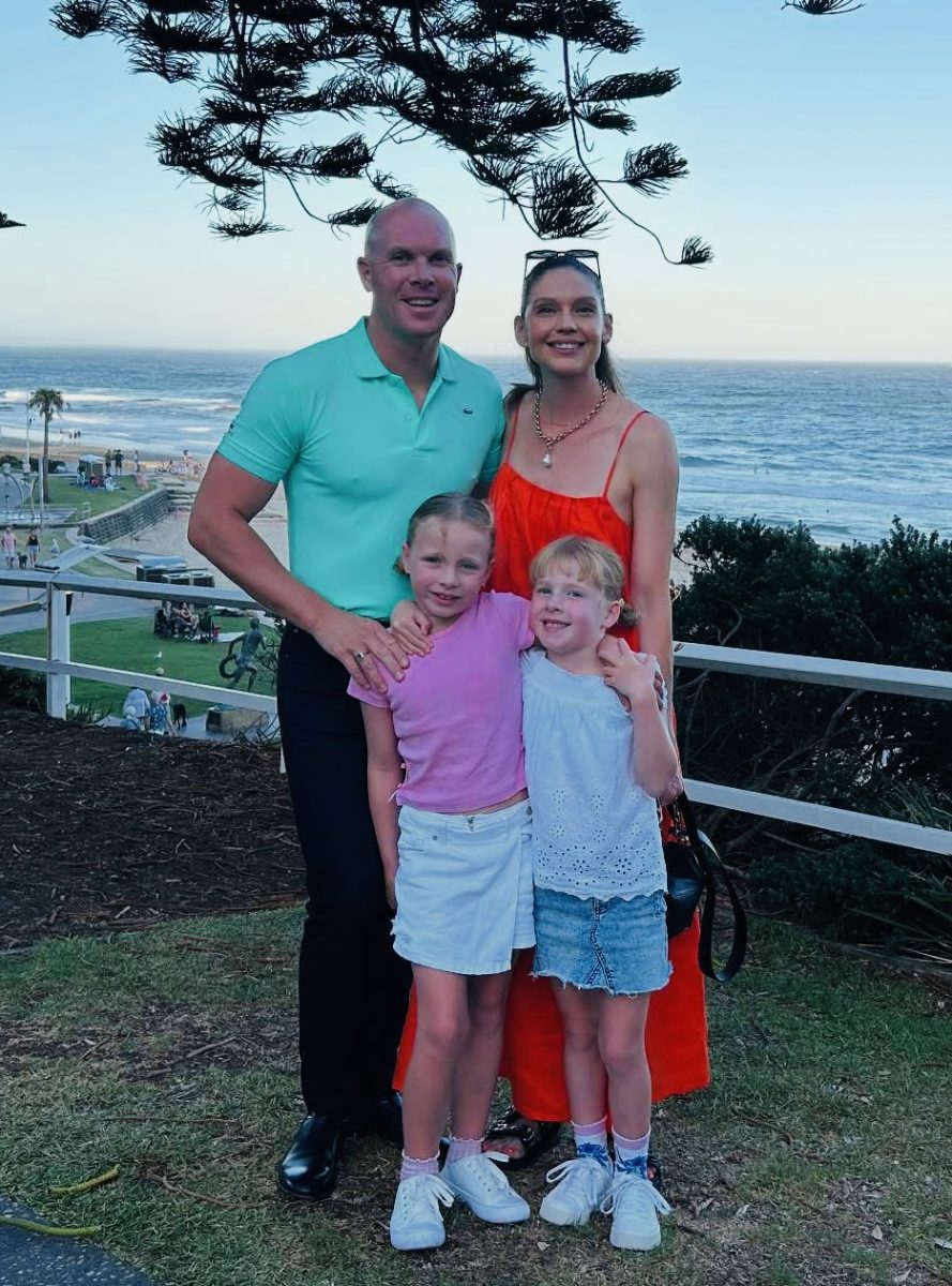 family photo in front of beach 